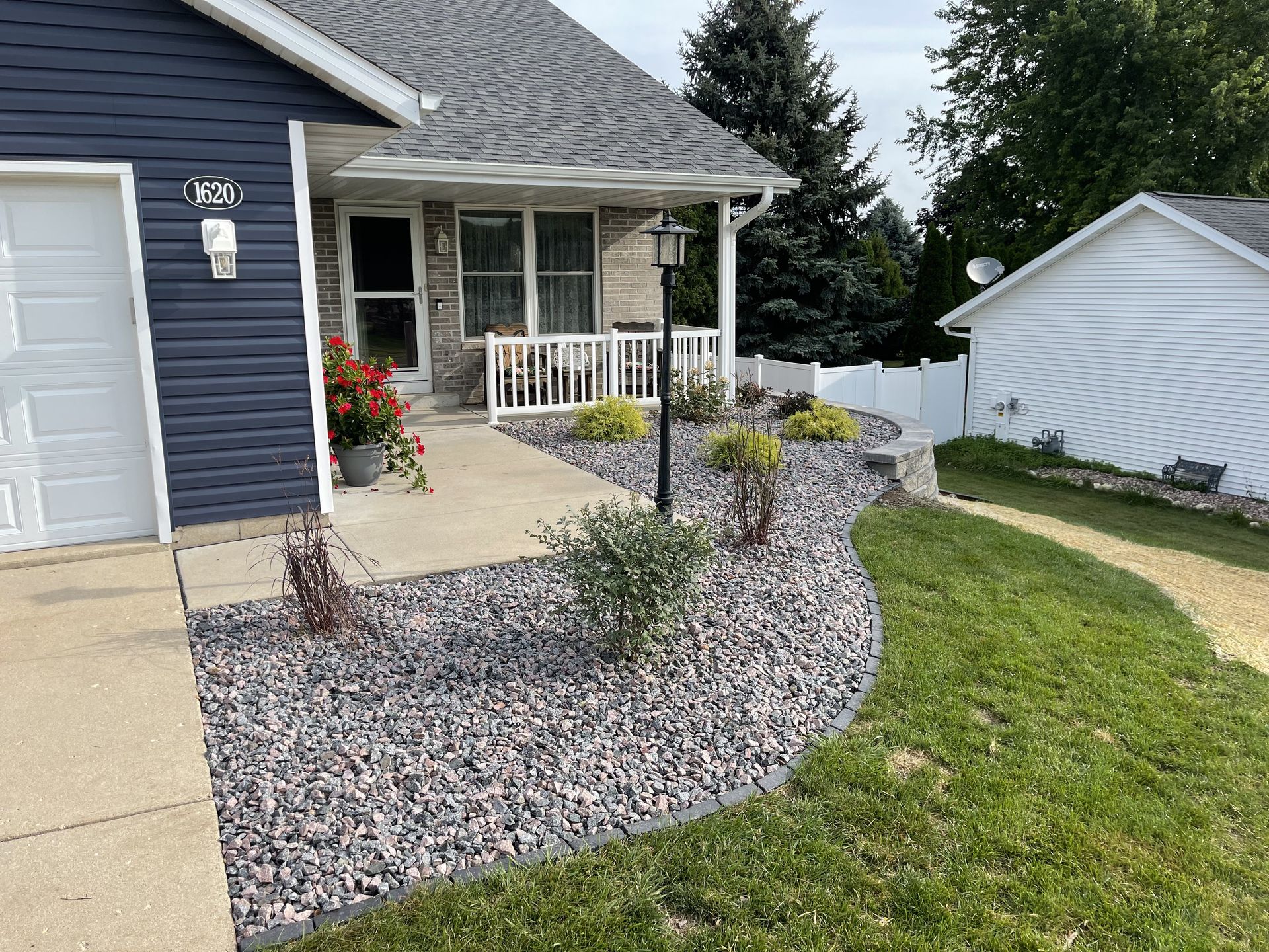 Brick patio beside house with white door and outdoor planter