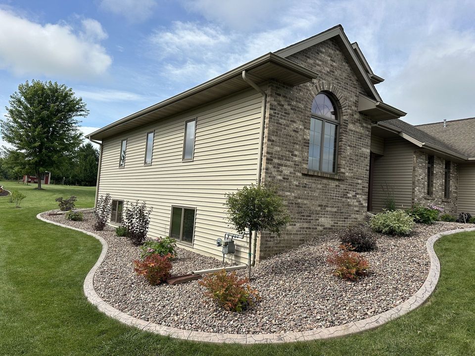 Landscaped garden bed with stacked stone edging and colorful plants in the Fond du Lac area
