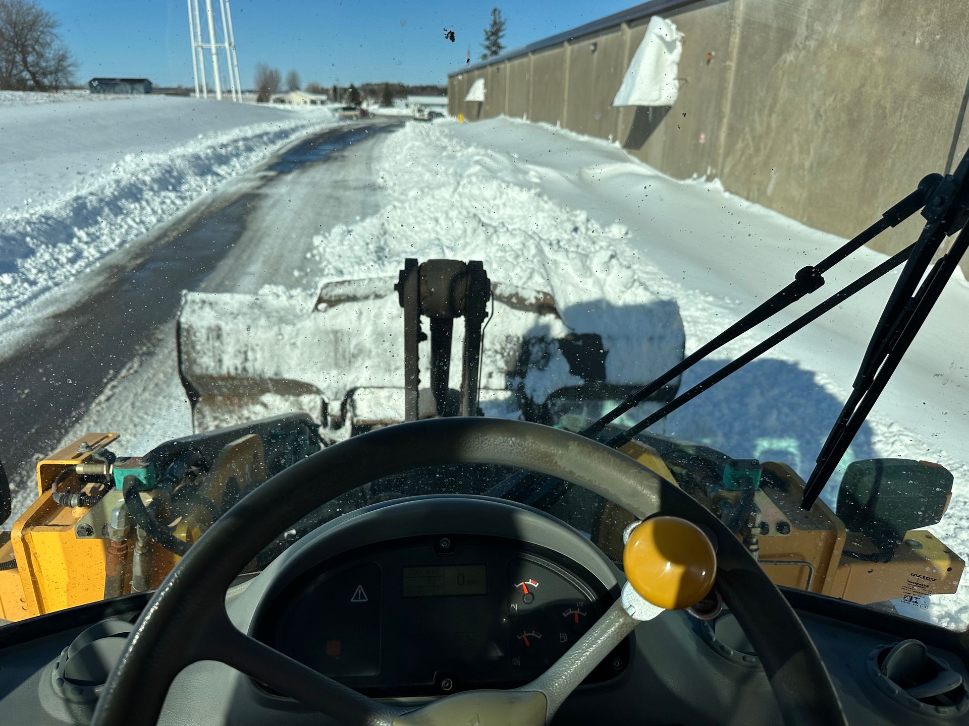 Snow-cleared sidewalk between high snowbanks on a sunny winter day
