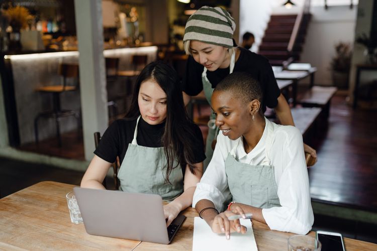 Diverse small-business team collaborating around a laptop