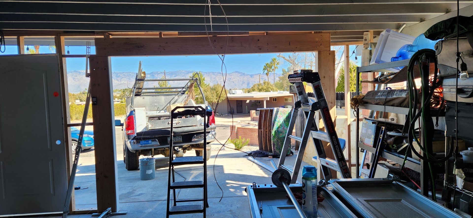 A garage under construction with a ladder and a truck parked in it.