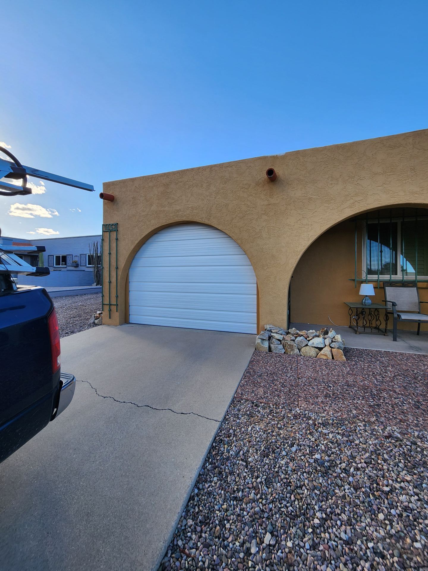 A truck is parked in front of a house with a white garage door