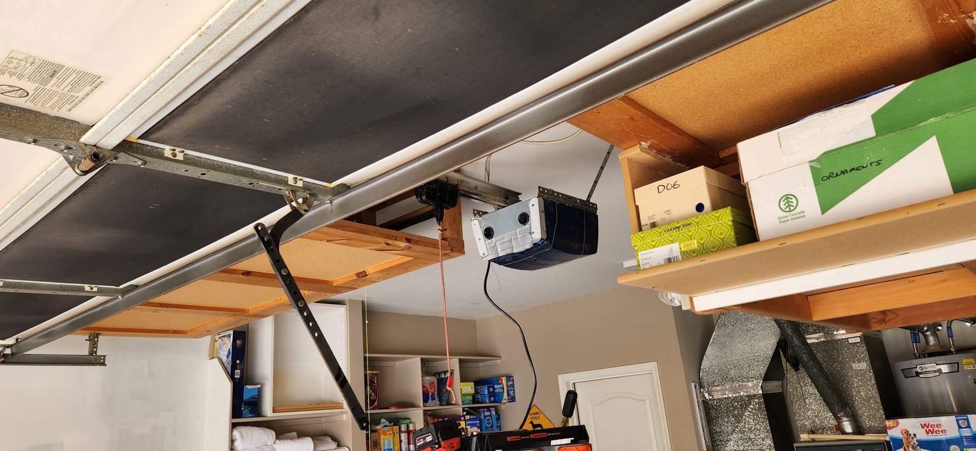 A garage door opener is hanging from the ceiling in a garage.