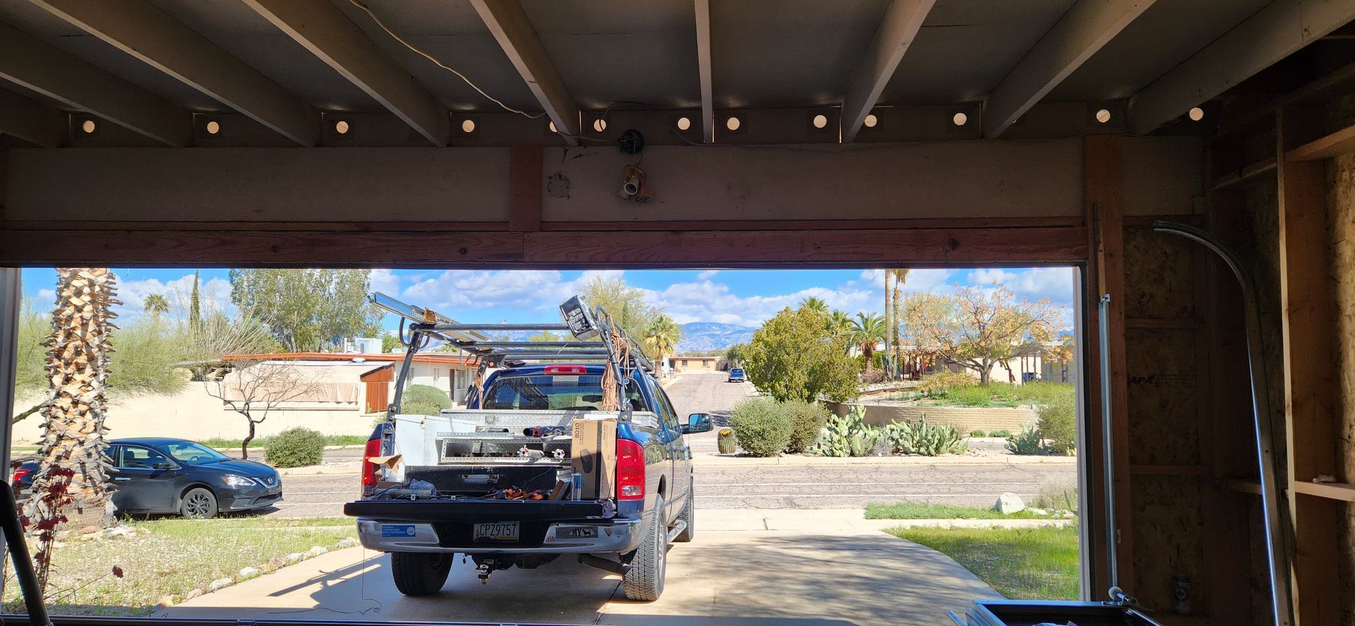 A truck is parked in a garage with the door open.