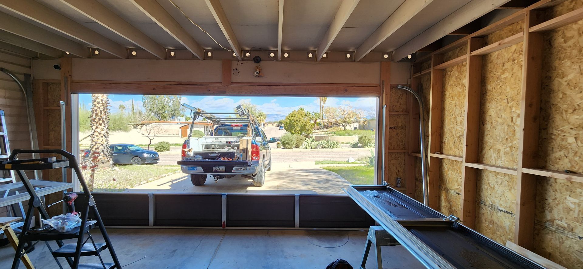 A truck is parked in a garage with a large window.