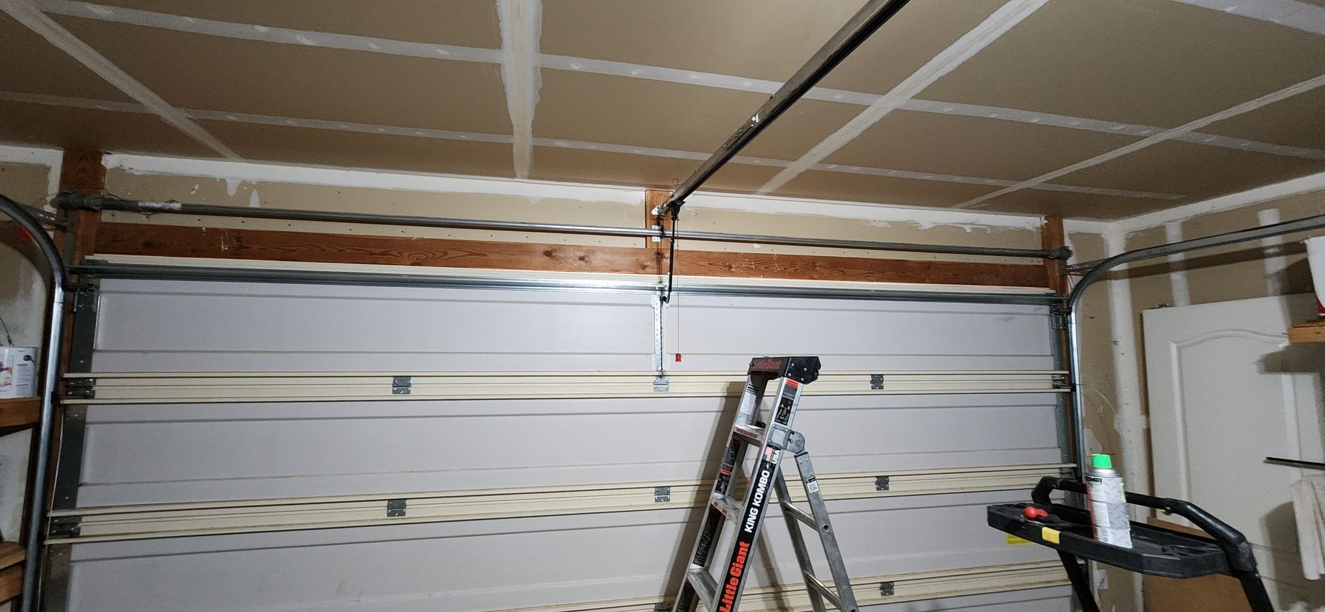 A garage with a ladder and a treadmill in it.