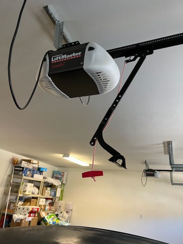 A garage door opener is hanging from the ceiling in a garage.