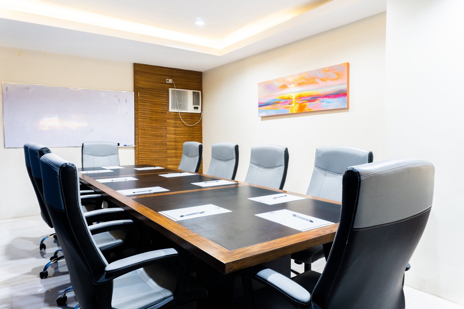 A conference room with a long table and chairs.