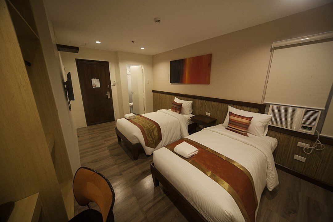 A hotel room with two beds and a desk