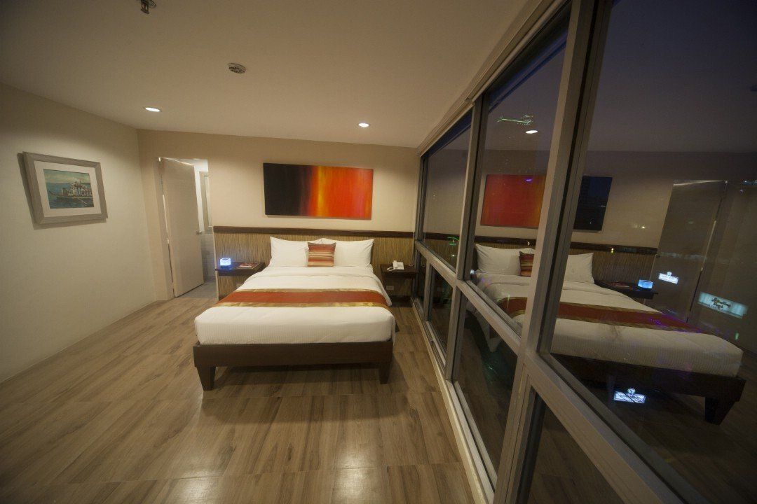 A hotel room with a bed and a large window