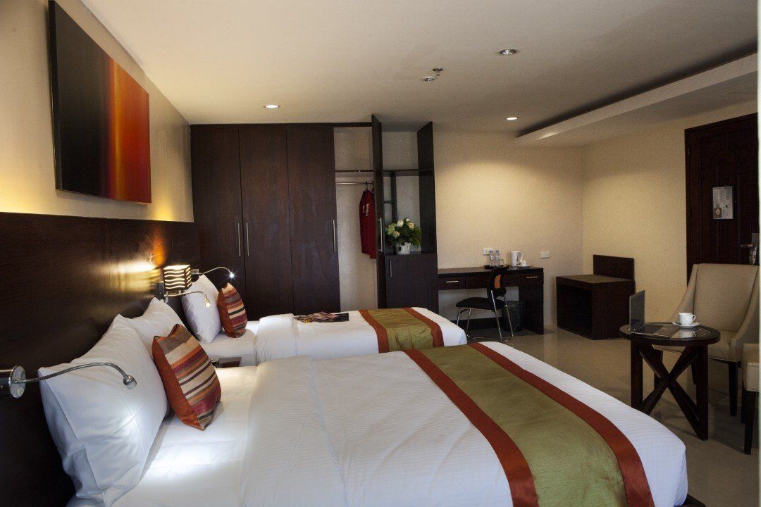 A hotel room with two beds and a desk
