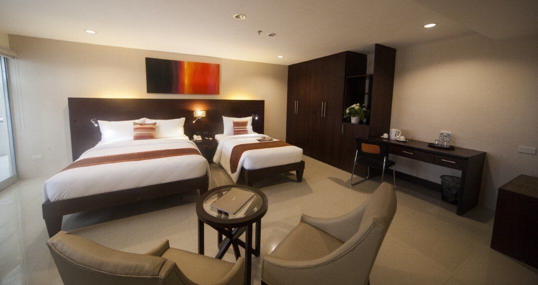 A hotel room with two beds and a couch