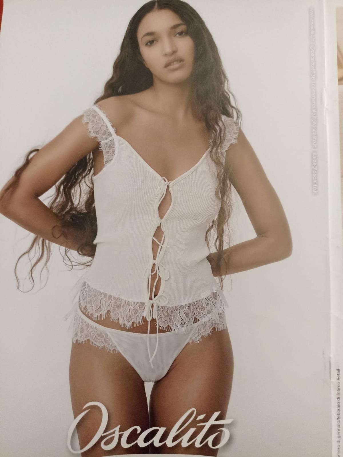 Donna in lingerie bianca in pizzo, top e slip. Logo