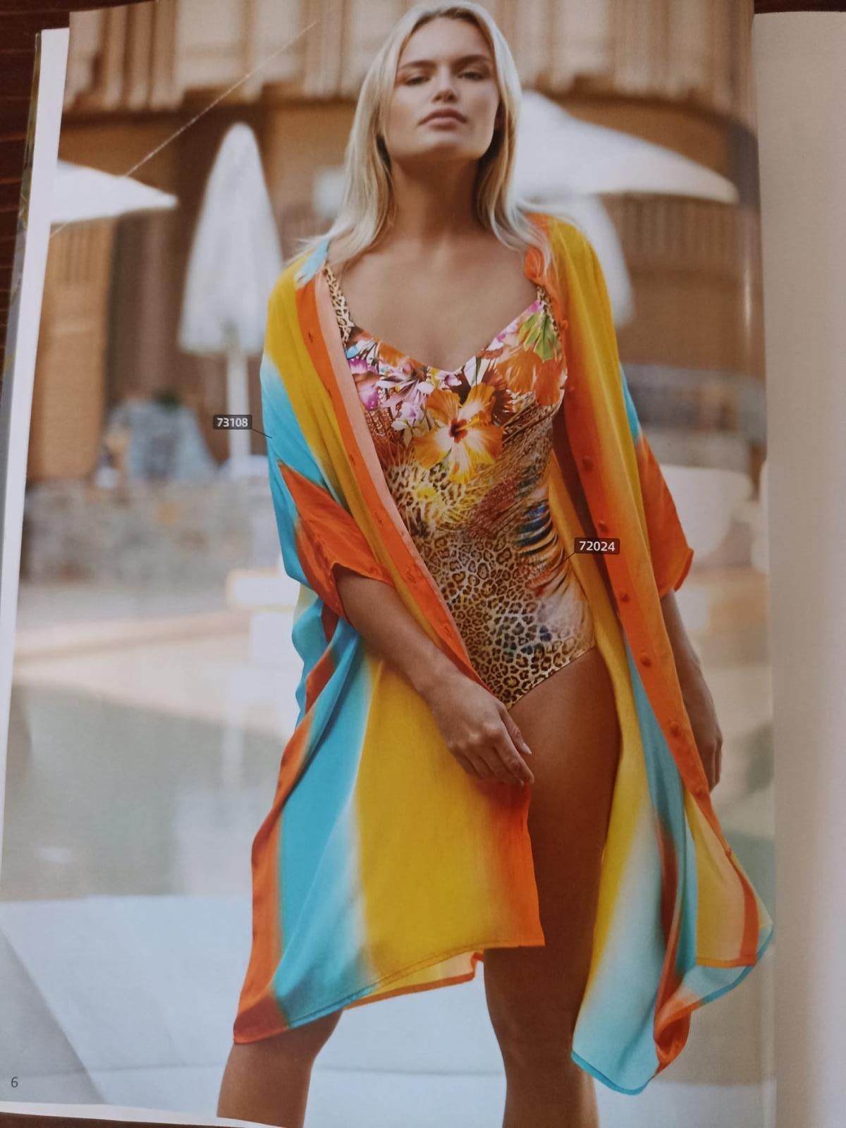 Donna in costume da bagno colorato e kimono a bordo piscina.