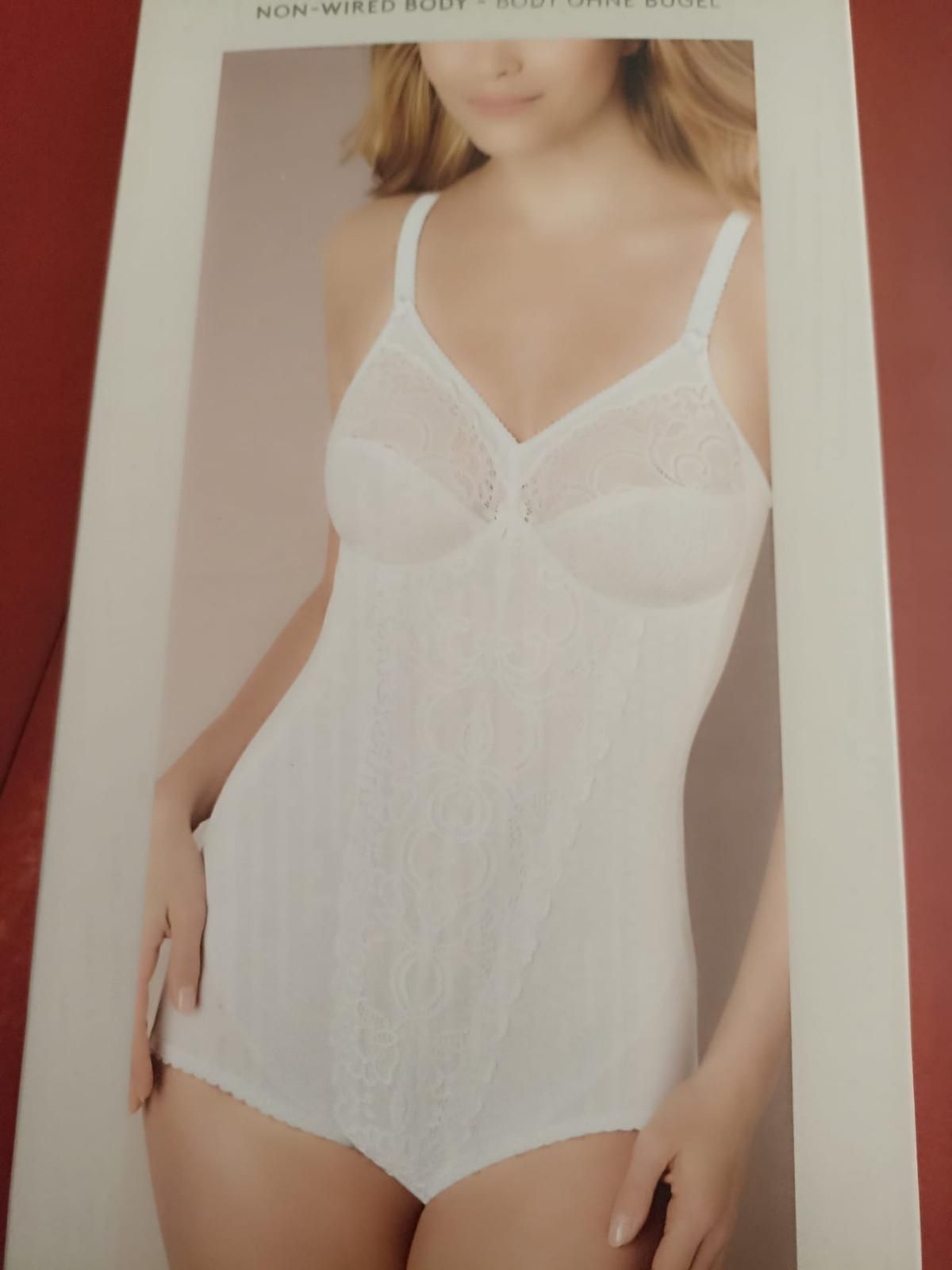 Tuta bianca indossata da una donna con i capelli biondi e le braccia lungo i fianchi, in una foto incorniciata del prodotto.