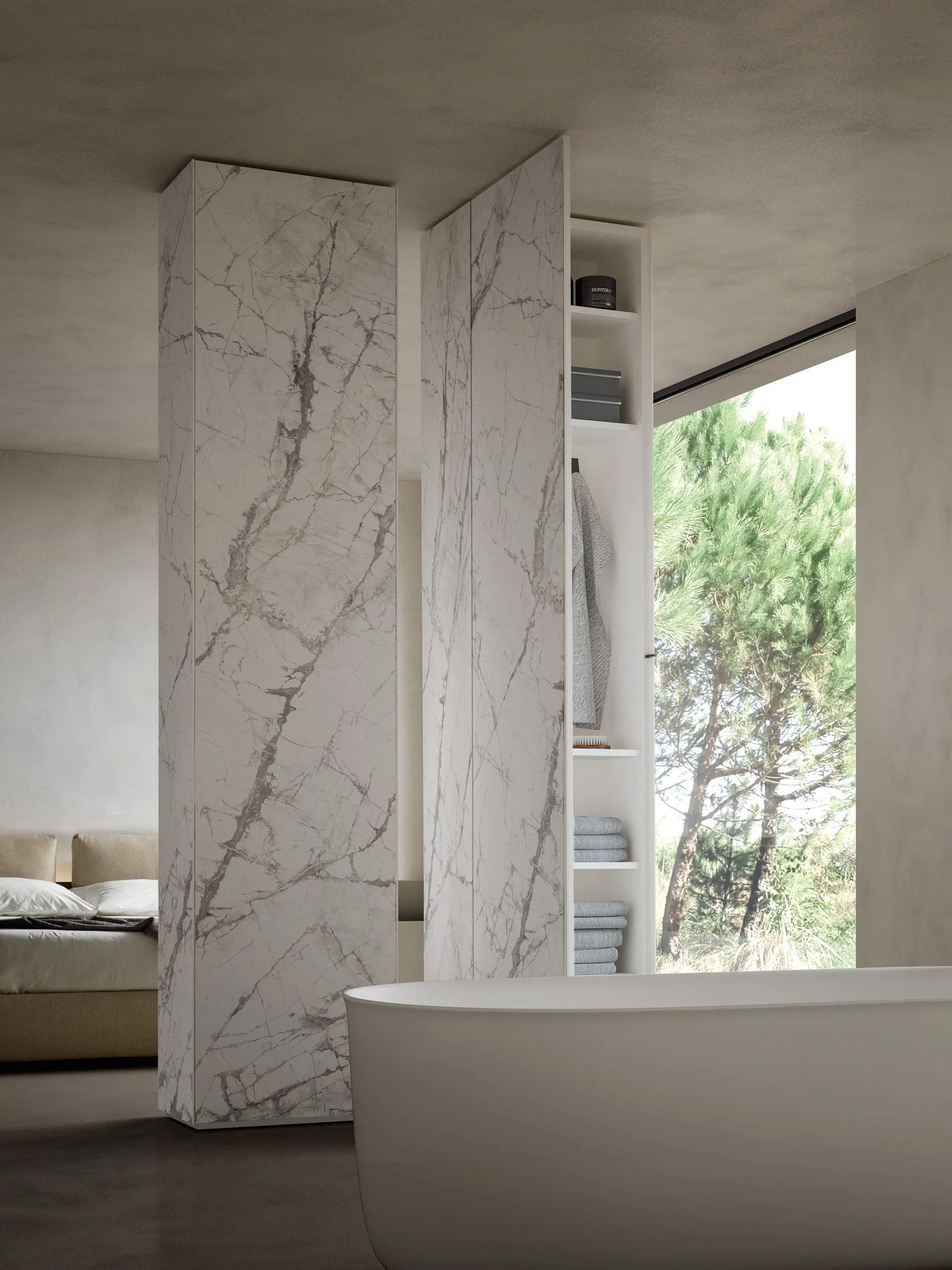 Bagno moderno con lavabo in marmo, mobile a giorno e vasca da bagno accanto a un'ampia finestra con vista sul verde.
