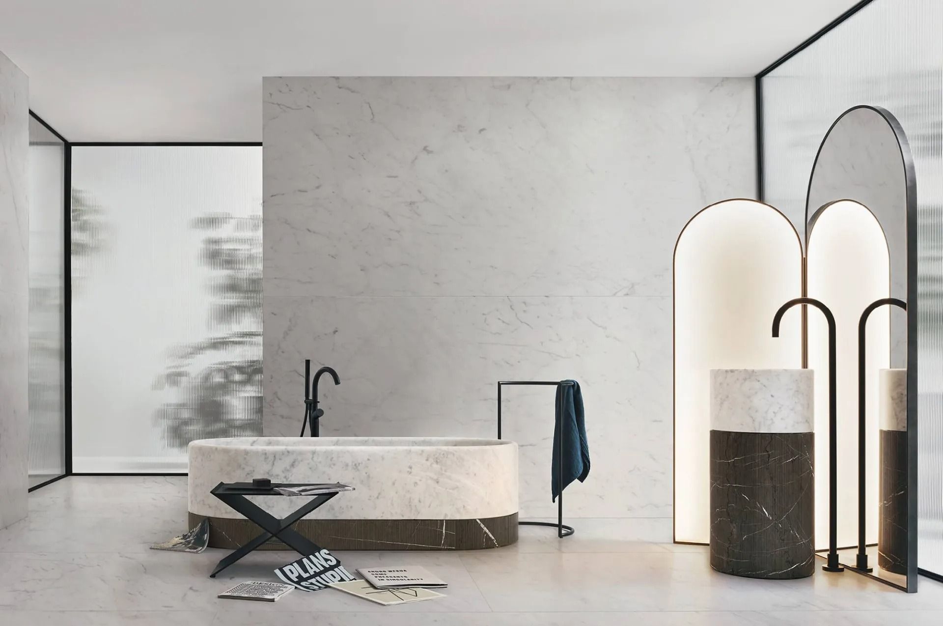 Bagno moderno e minimalista con vasca freestanding, rubinetteria nera e specchio a pavimento ad arco.