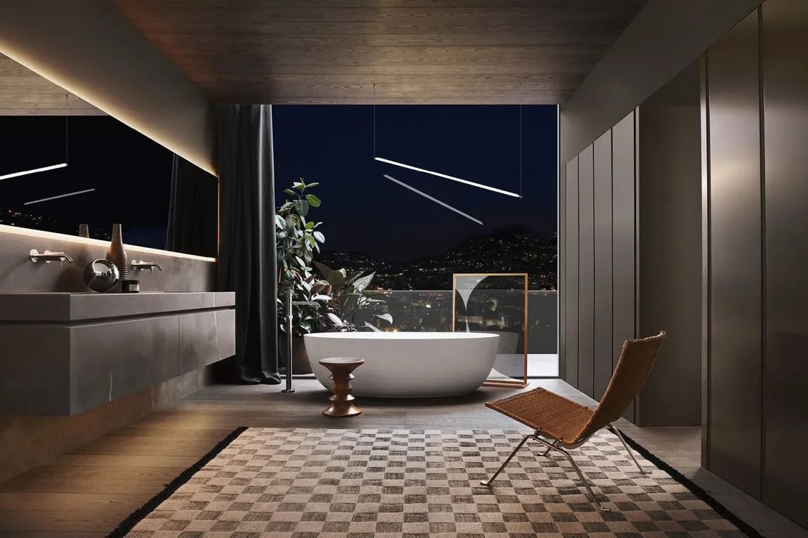 Bagno moderno con vasca freestanding, sedia in legno e vista sulla città di notte.