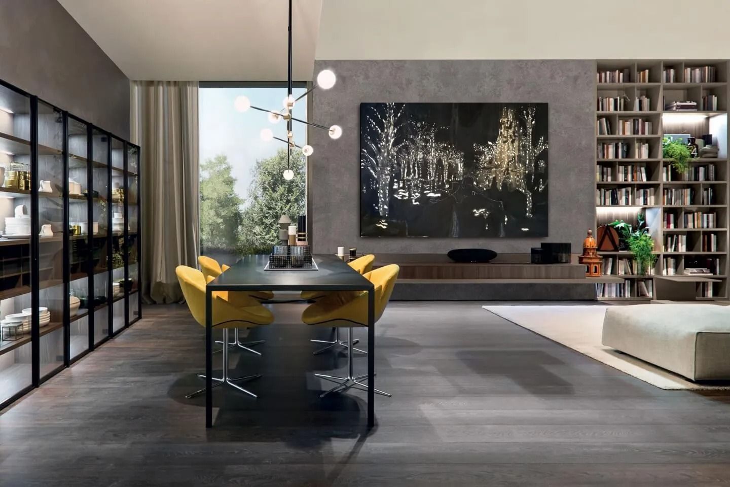 Sala da pranzo moderna con tavolo in vetro, sedie gialle, quadri scuri alle pareti e librerie alte.