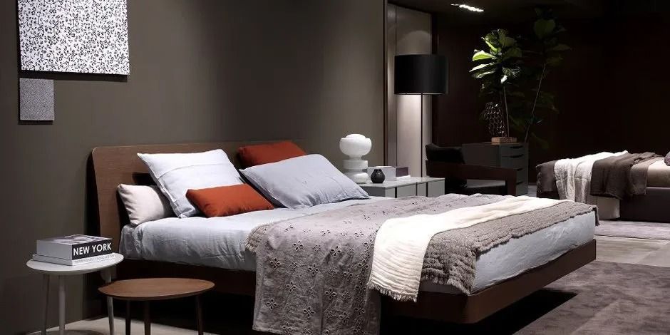 Camera da letto moderna con letto ben rifatto, pareti grigie e comodino con decorazioni