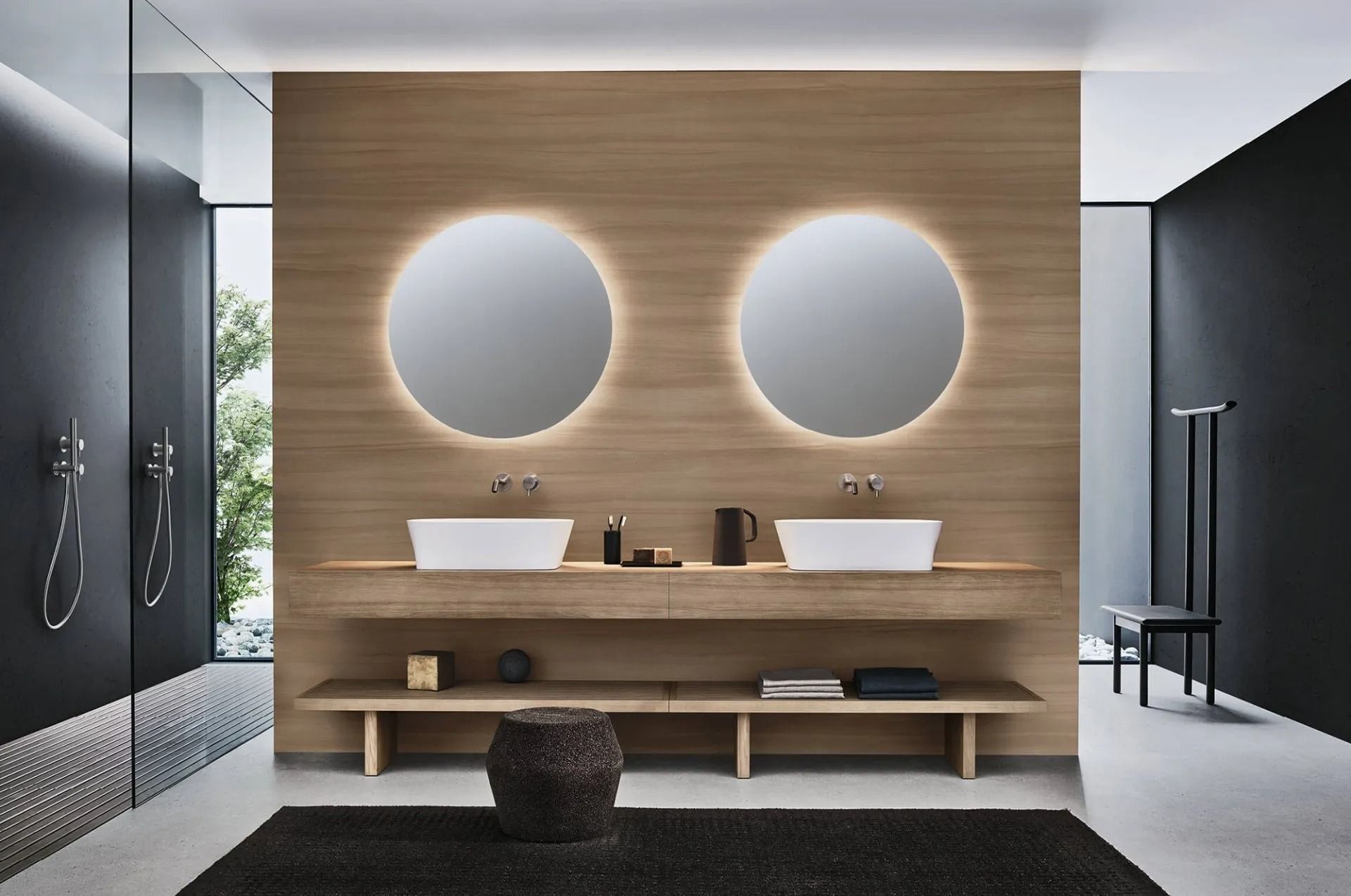 Mobile bagno moderno con doppio lavabo, specchi rotondi retroilluminati e parete rivestita in legno.