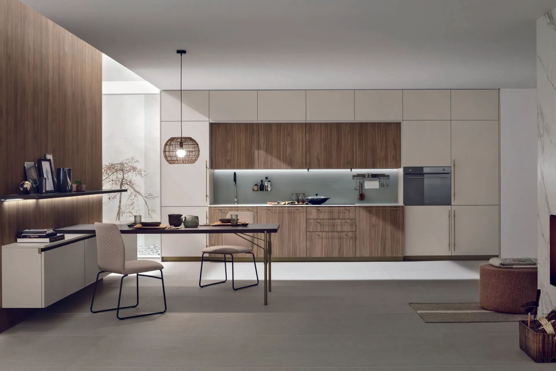 Cucina e zona pranzo moderne e minimaliste con mobili in legno, pareti bianche e un tavolo accanto a una grande finestra.
