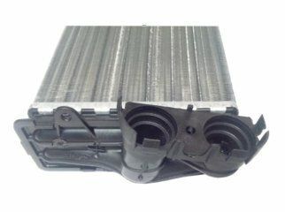 Primer plano de un intercambiador de calor automotriz de metal plateado con tapas de plástico negro en los extremos.