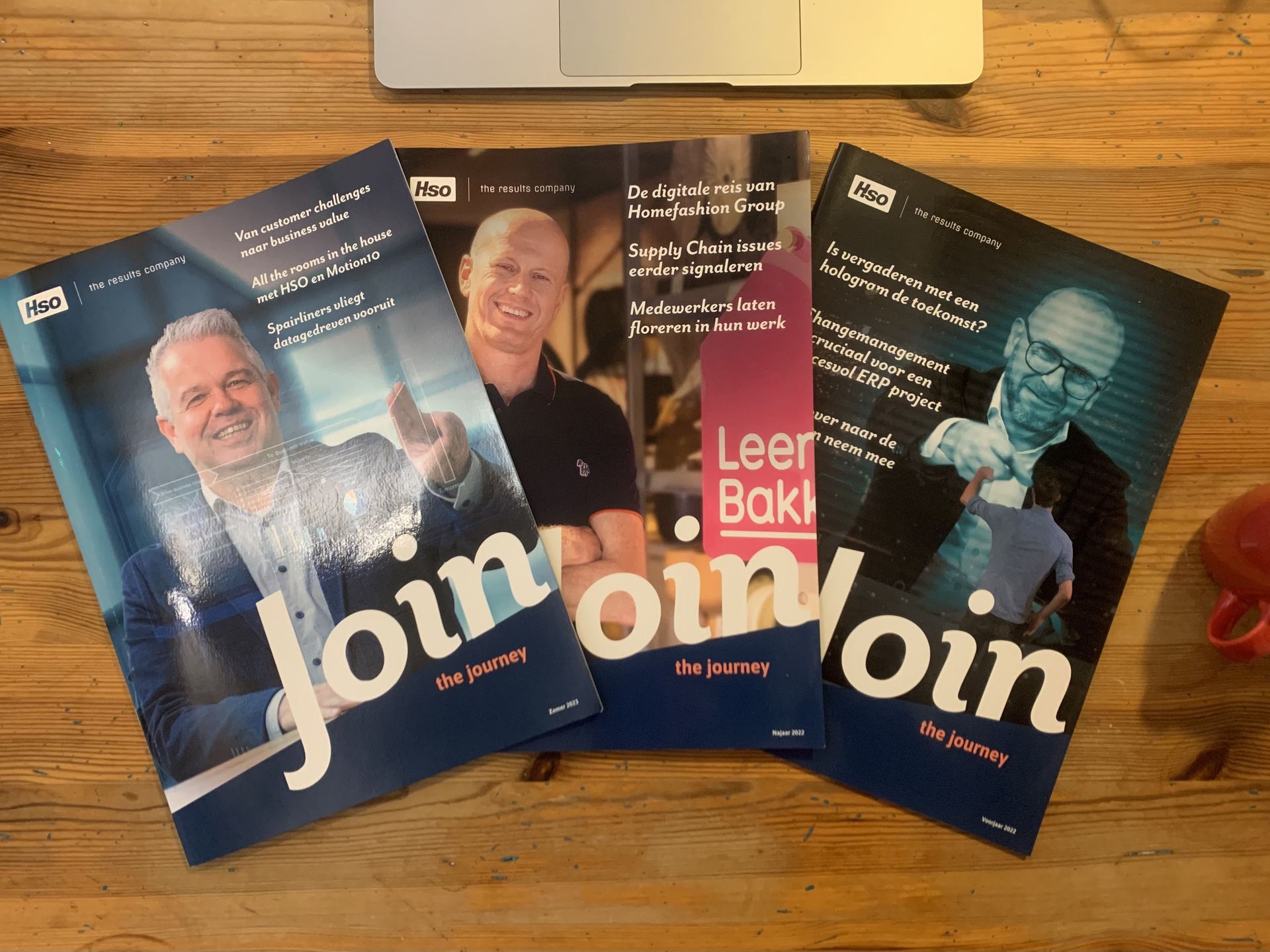 Drie tijdschriften met mensen op de omslag, blauw en wit met de tekst 