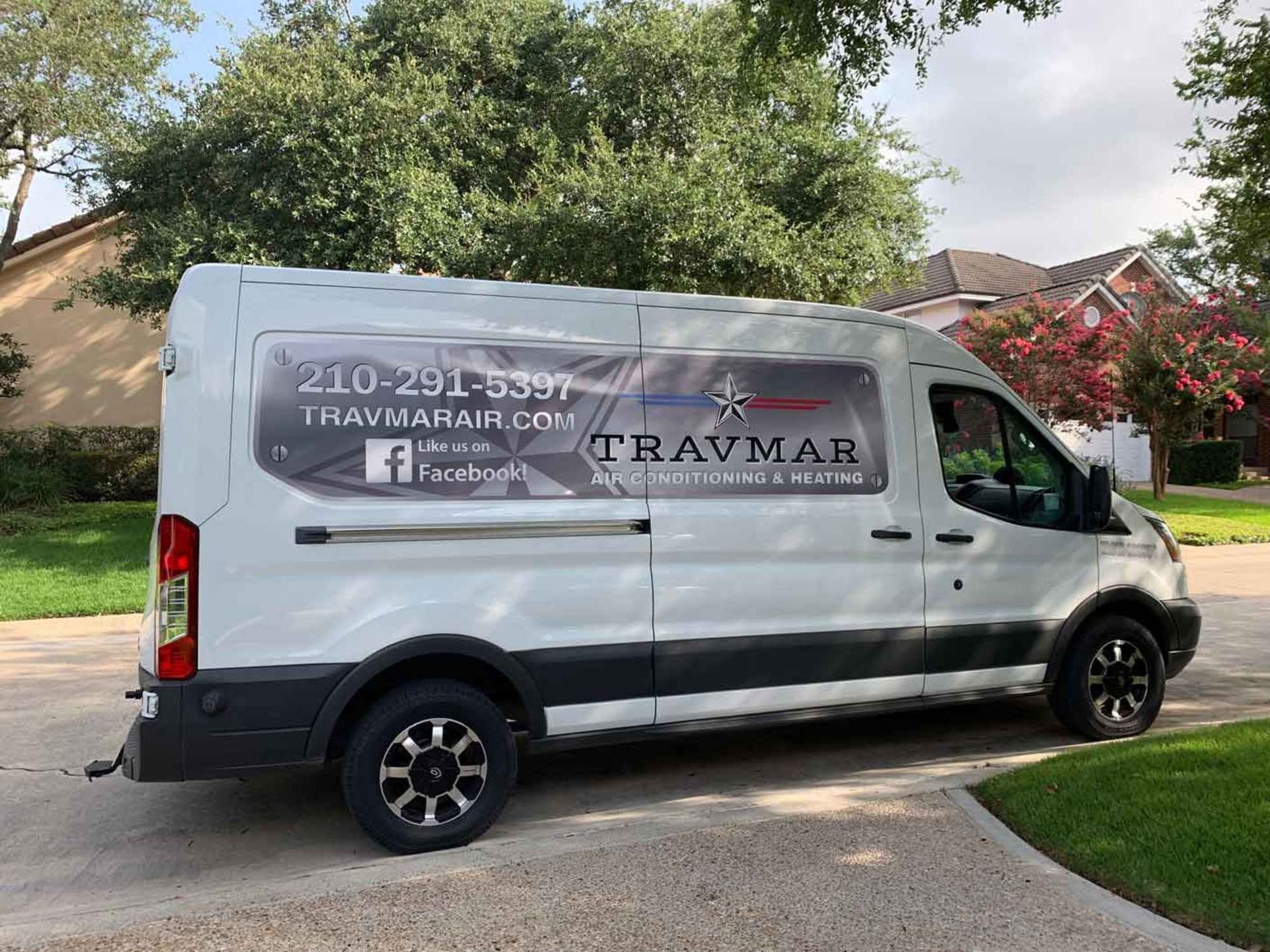 a white van is parked in a driveway in front of a house .