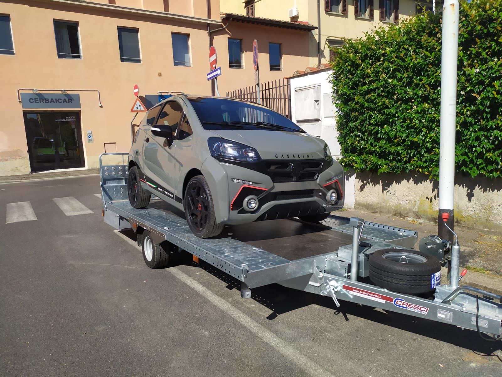 Un'auto è parcheggiata sopra un rimorchio sul ciglio della strada.