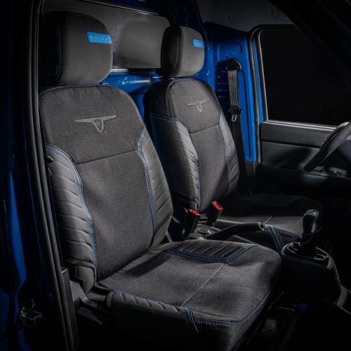 L'interno di un furgone blu con sedili neri e volante.