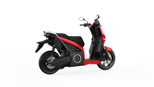 Uno scooter rosso e nero è parcheggiato su uno sfondo bianco.