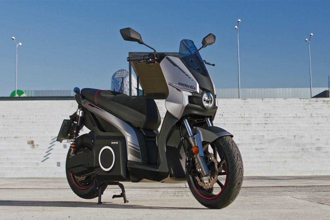 Uno scooter è parcheggiato davanti a un muro bianco.