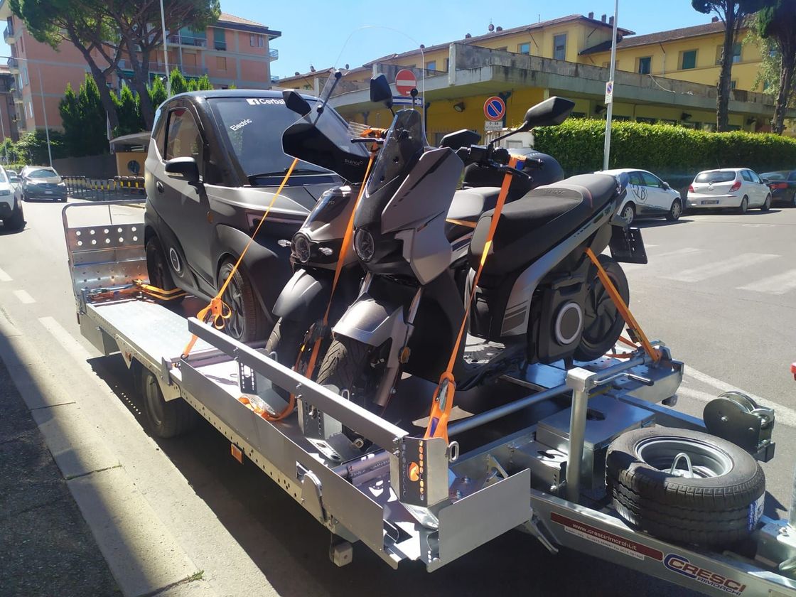 Un rimorchio con due motociclette e un'auto sopra