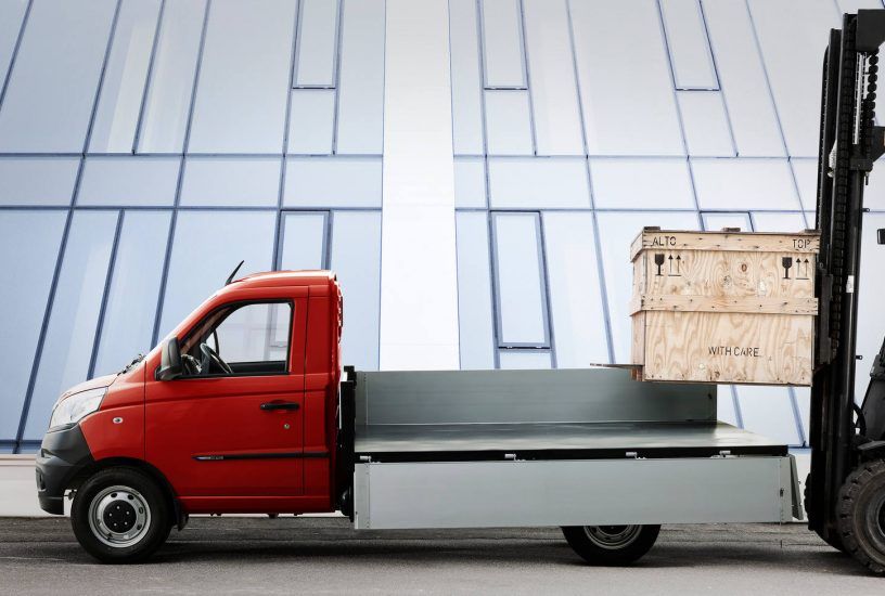 Un camion rosso viene trainato da un carrello elevatore