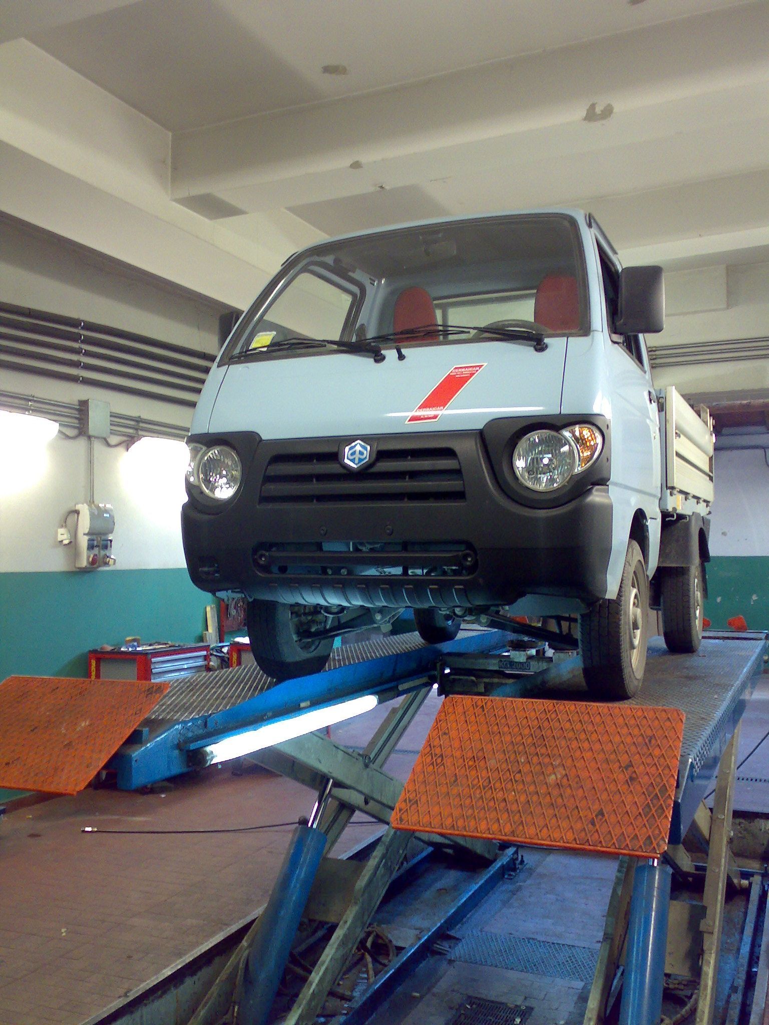 Un camion bianco è parcheggiato su un sollevatore in un garage