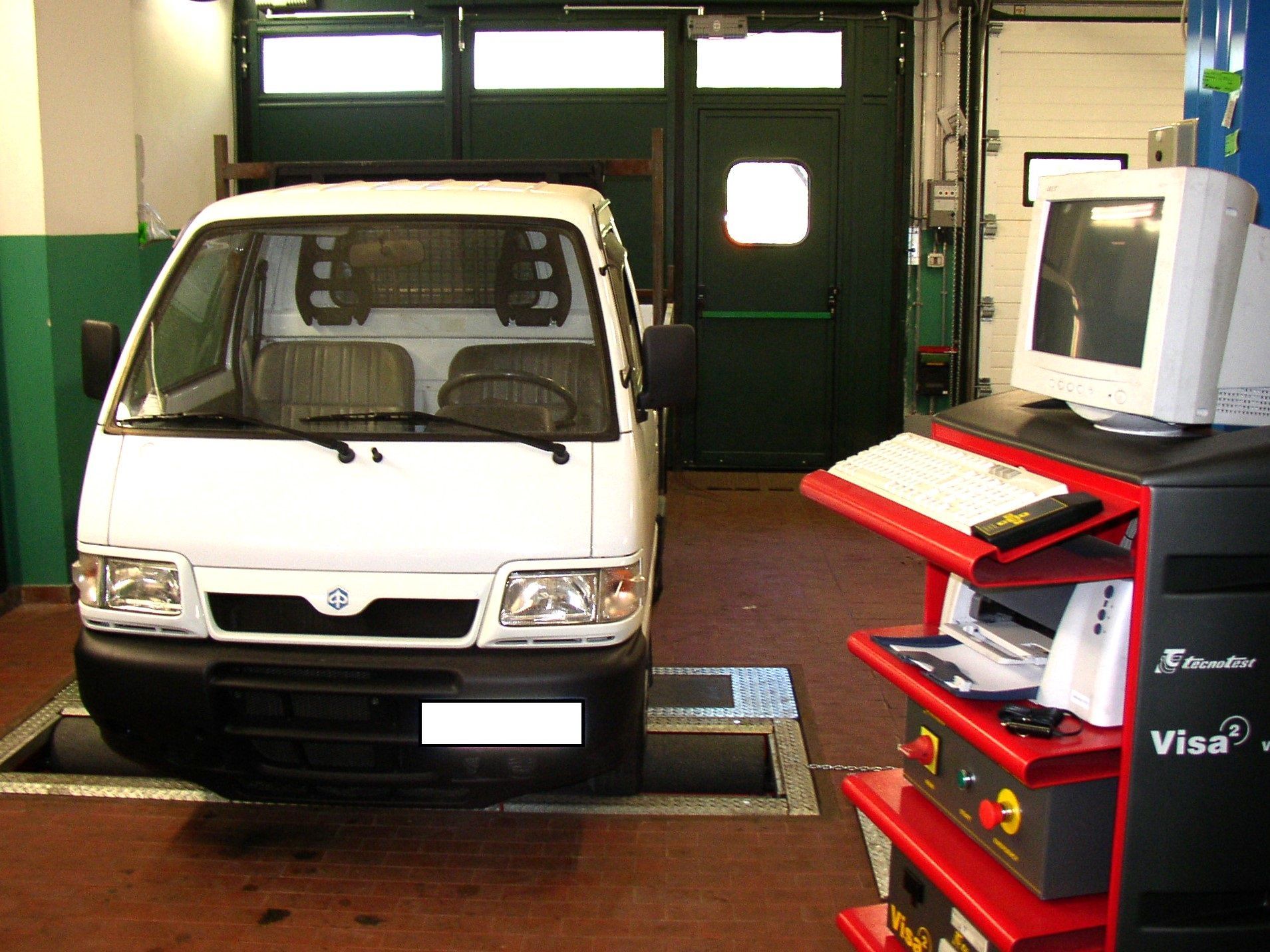 Un furgone bianco è parcheggiato in un garage accanto a un computer