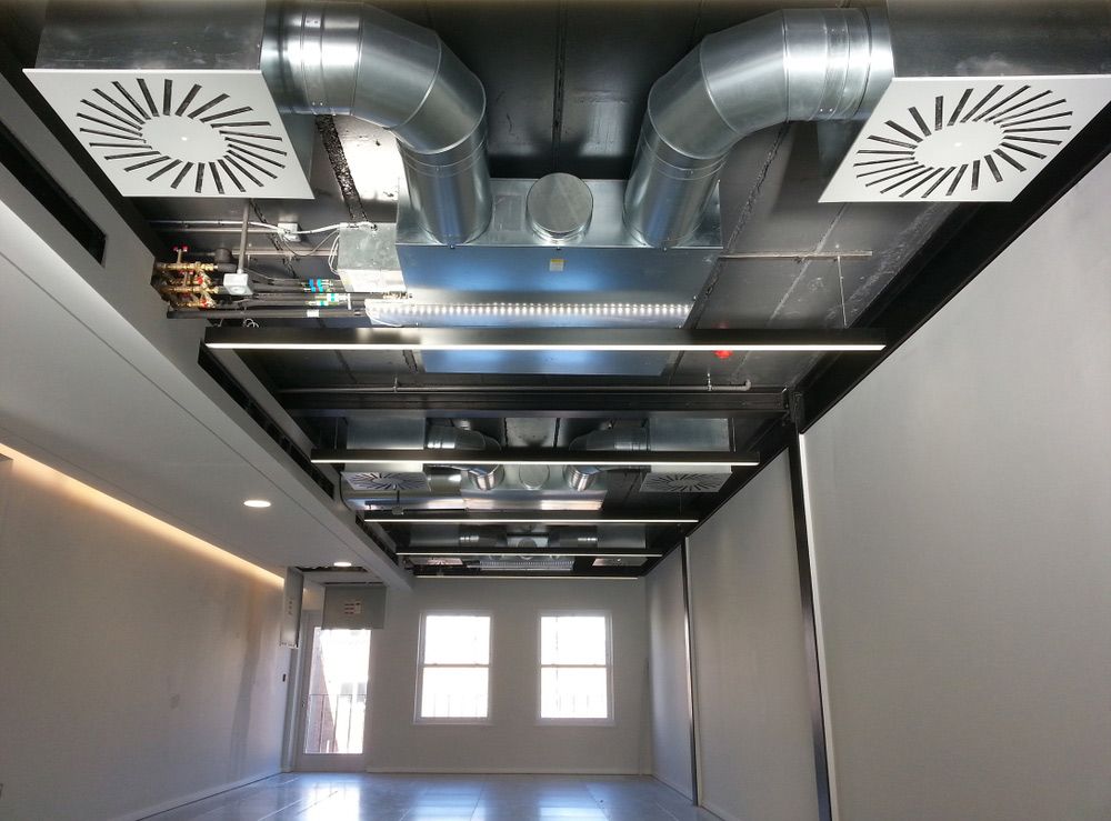 A Room with A Lot of Duct Air Conditioner Pipes Hanging from The Ceiling — Revive Air Conditioning in Narellan, NSW