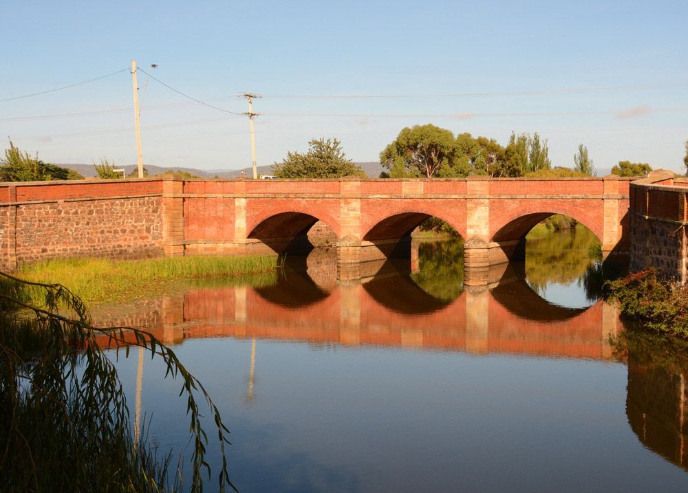 A Bridge Over a Body of Water with Trees in The Background — Revive Air Conditioning in Campbelltown, NSW