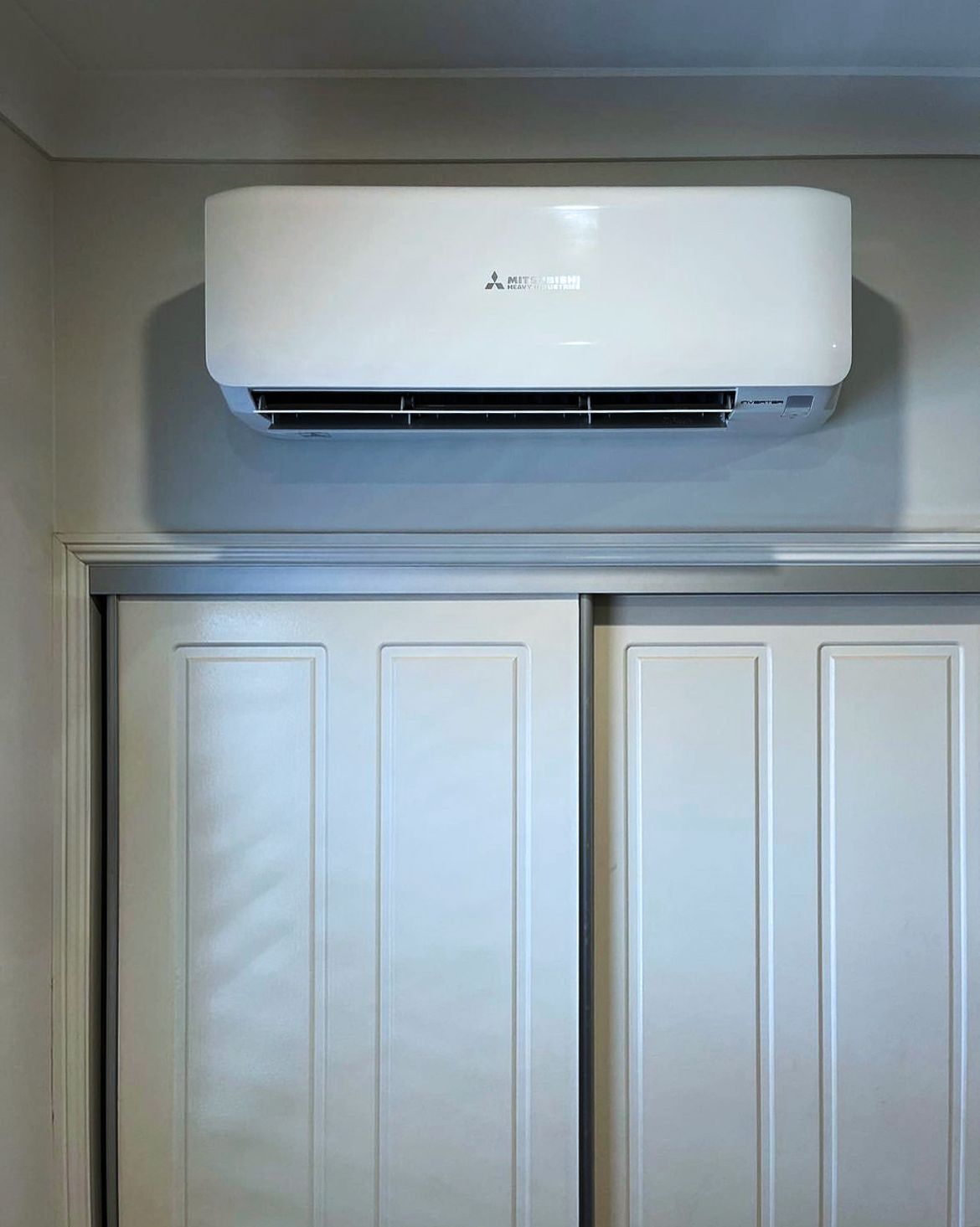 Split system over sliding white doors — Revive Air Conditioning in Campbelltown, NSW