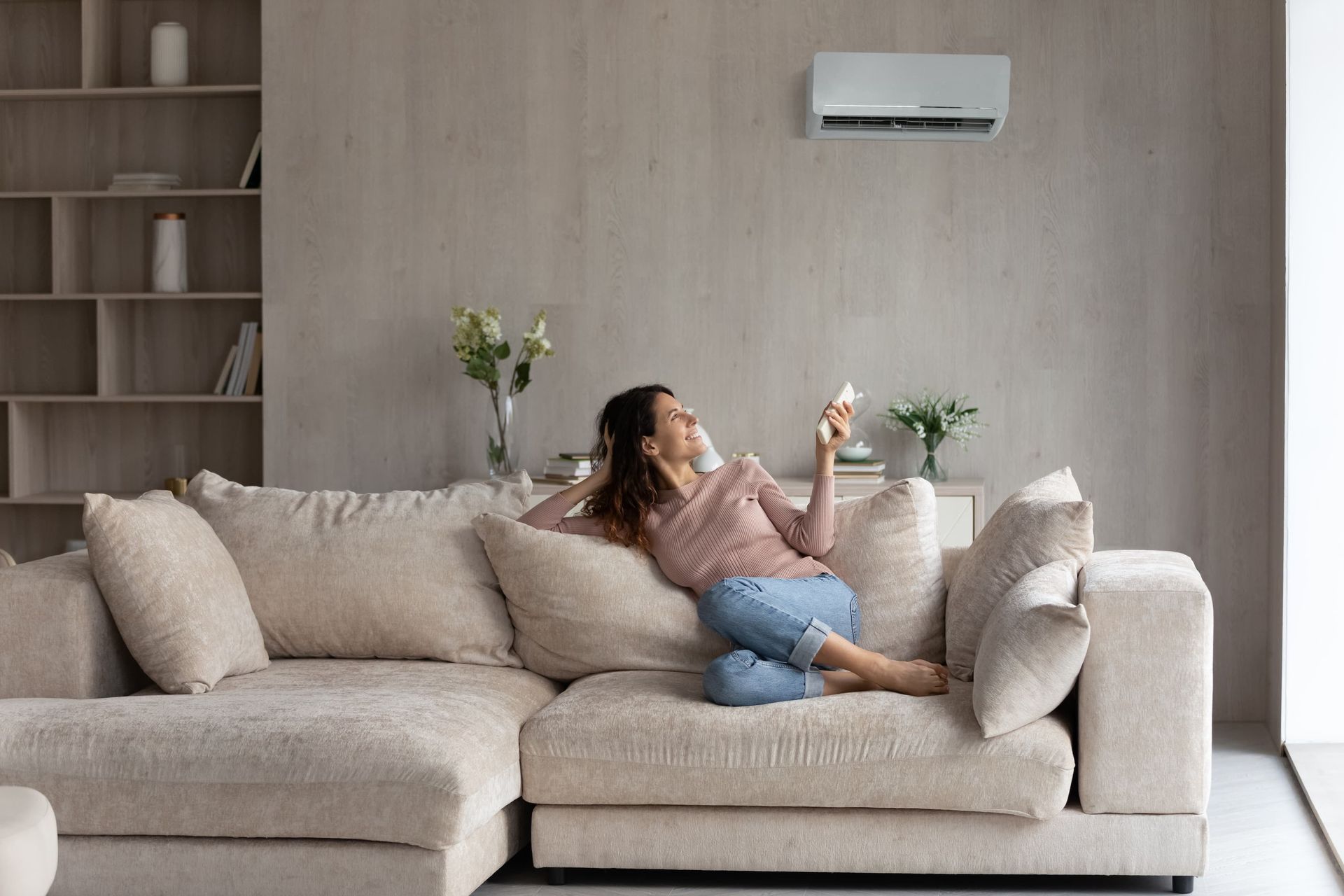 A White Air Conditioner Is Mounted on The Side of A Building — Revive Air Conditioning in Campbelltown, NSW