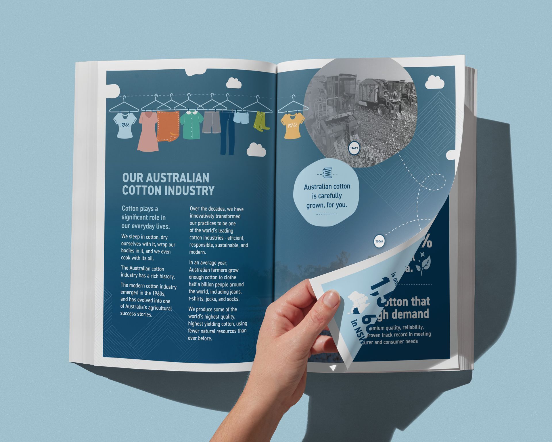 Hand holding open a blue-and-white magazine spread with charts and text in sunlight