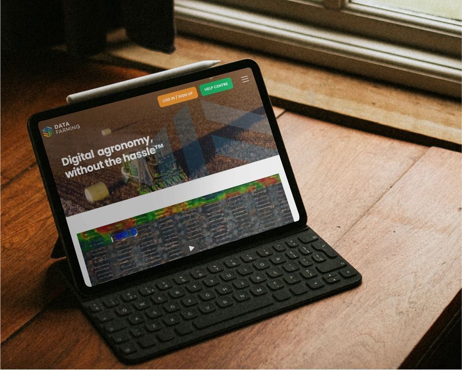 Tablet on a wooden table showing a web page, with a keyboard case and sunlight from a window