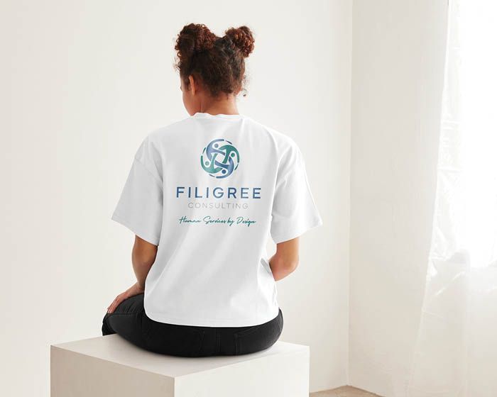 A woman is sitting on a cube wearing a white t-shirt.