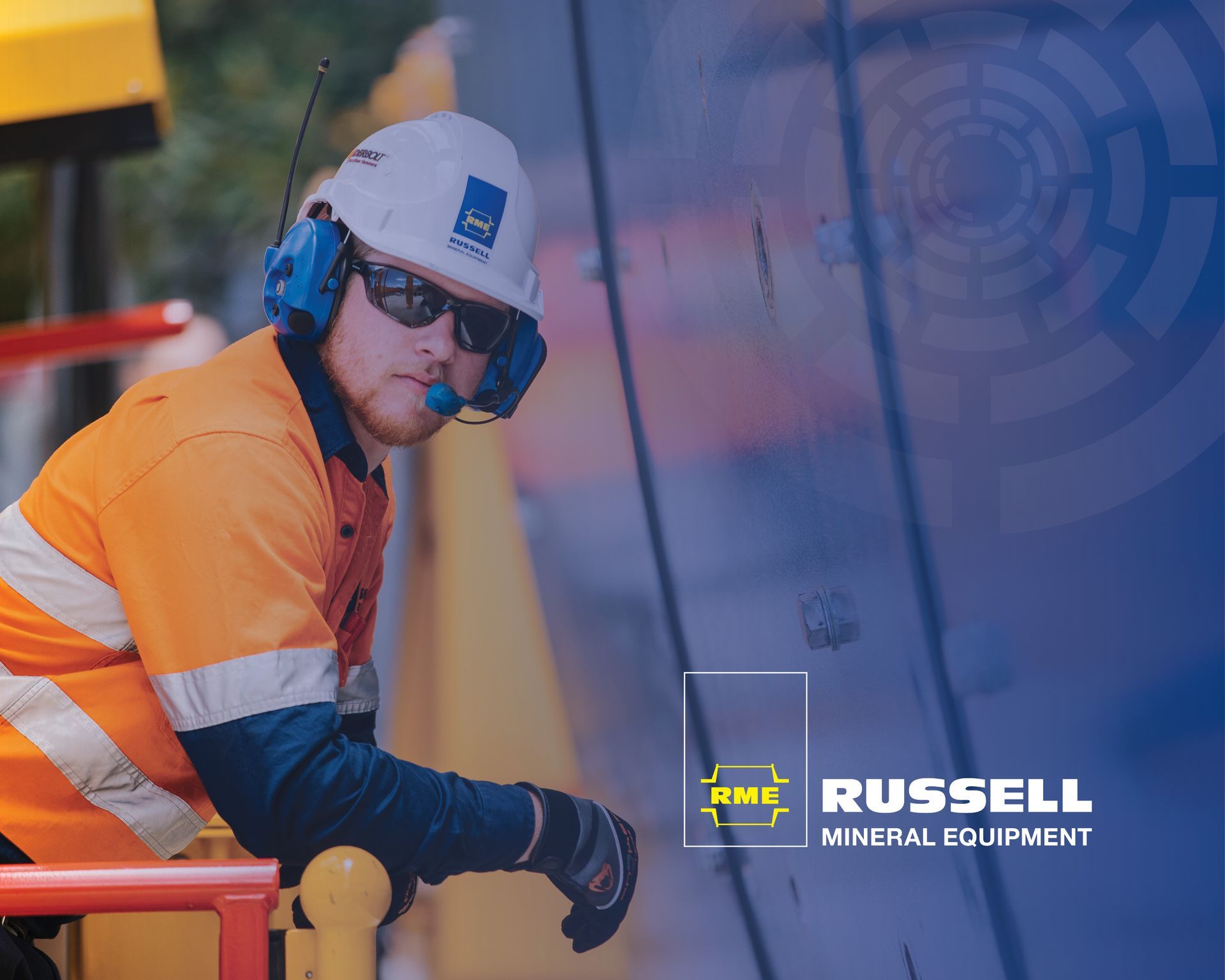 Worker in orange safety gear and hard hat using a tool at an industrial site, with “Russell Mineral Equipment” logo.