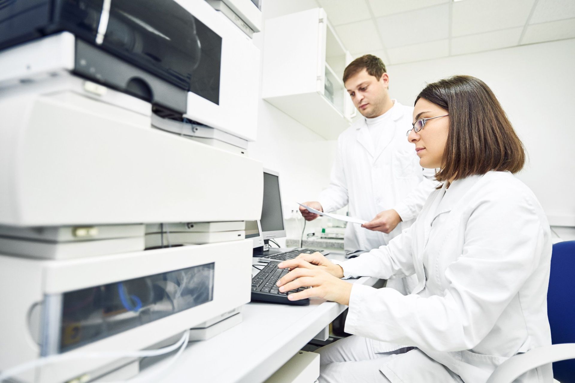 a man and a woman are working on a computer in a lab