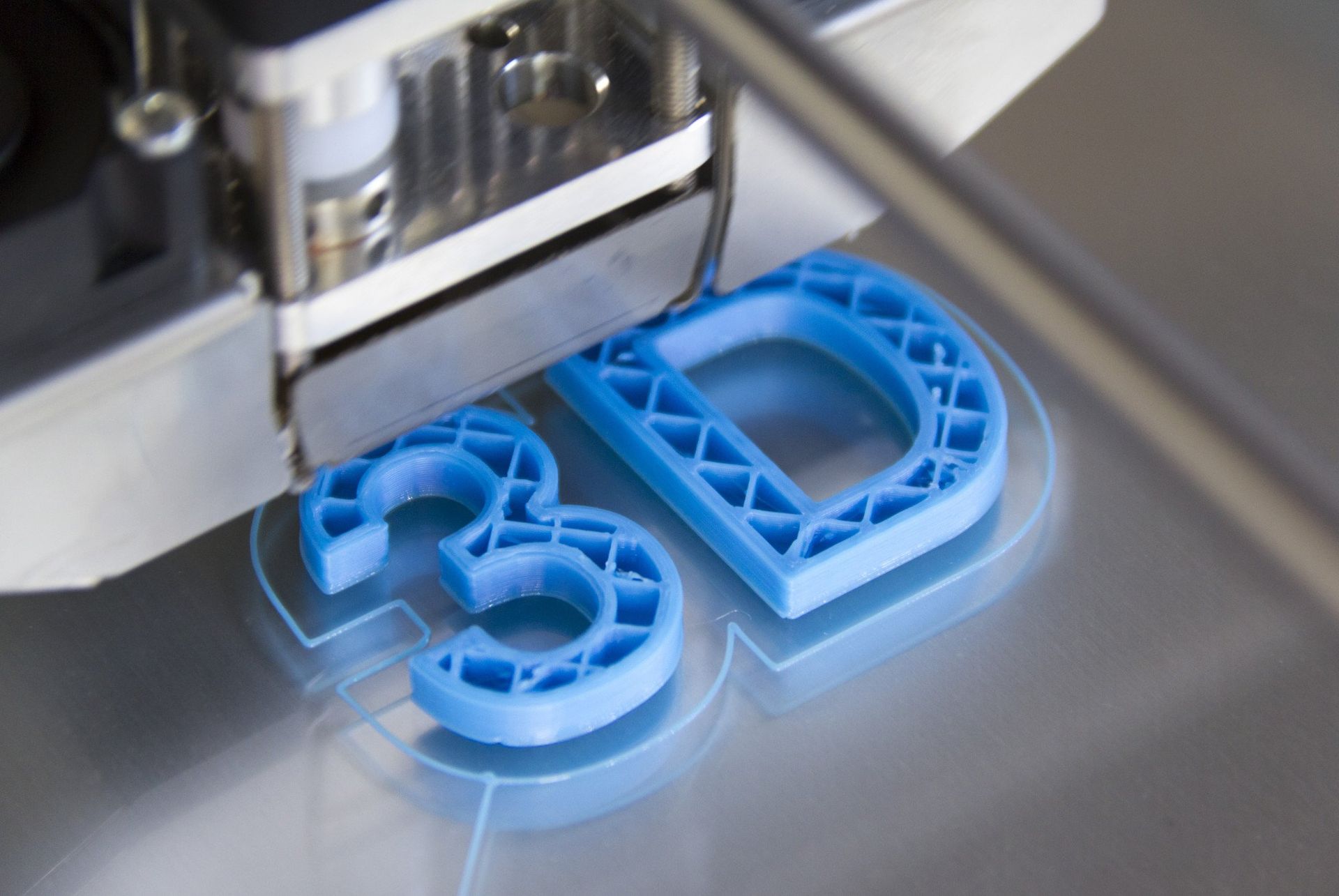 the word 3d is being printed on a clear surface