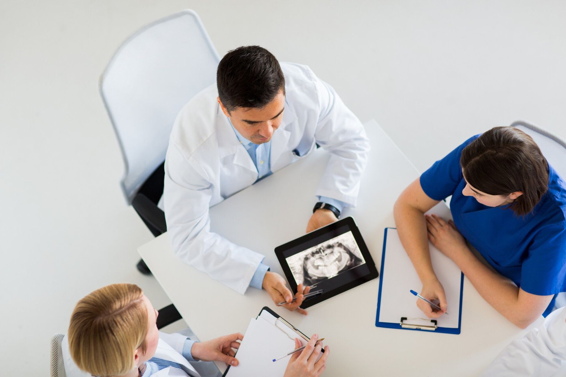 a group of doctors are looking at an x-ray on a tablet