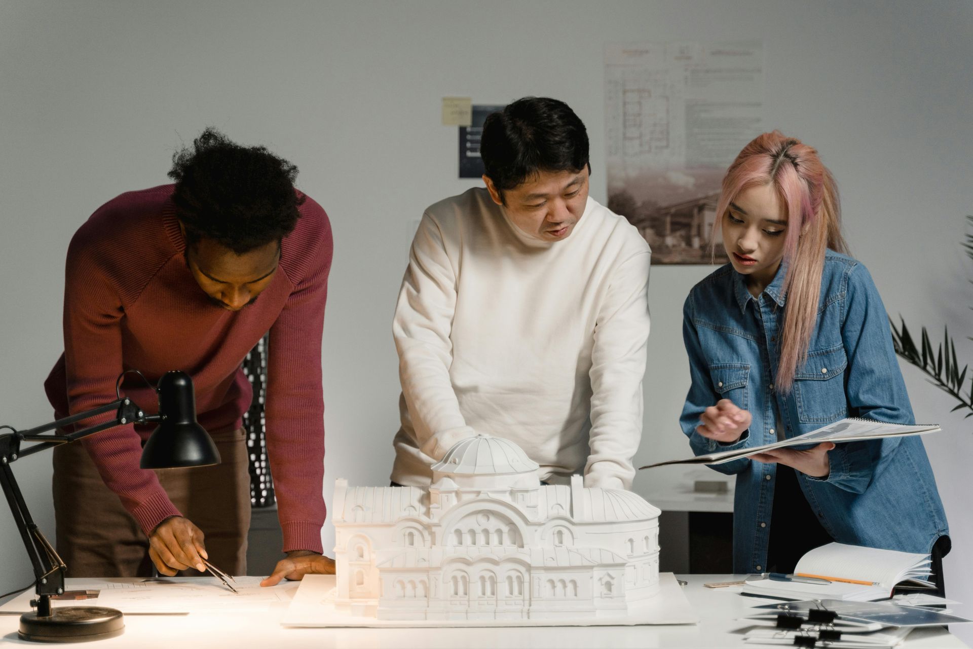 Un groupe de personnes regarde une maquette d'un bâtiment.