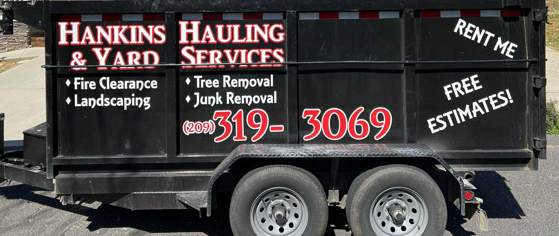Black dumpster trailer with Hankins Hauling & Yard Services, phone number, and